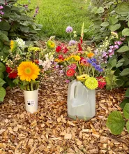 Cup and milk jug of cut flower arrangment.