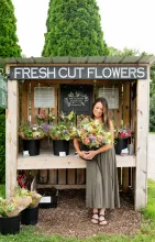 woman holding fresh flowers at roadside flower stand