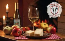 Wine, cheese and apples on a candle lit table